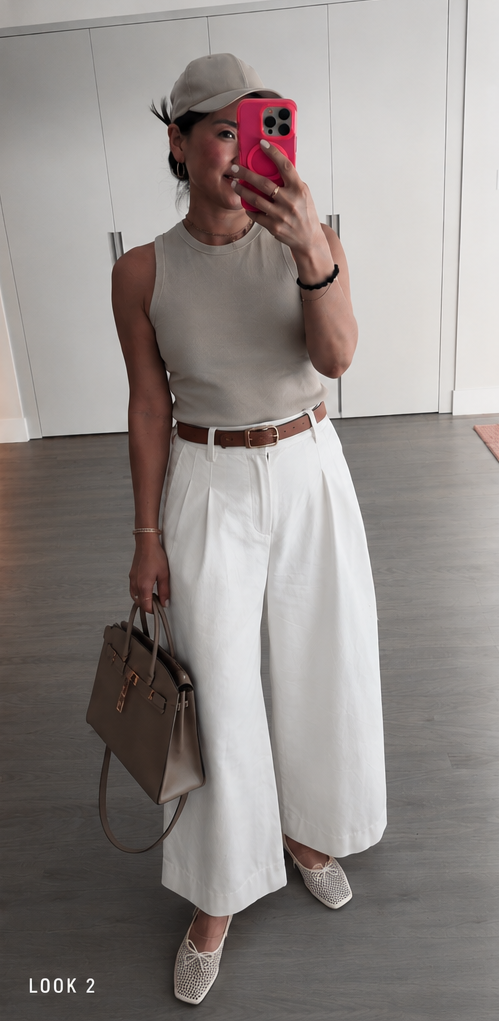 Luxemix wide-leg white parachute pants styled with a sage tank top, brown leather belt, structured taupe handbag, and mesh ballet flats