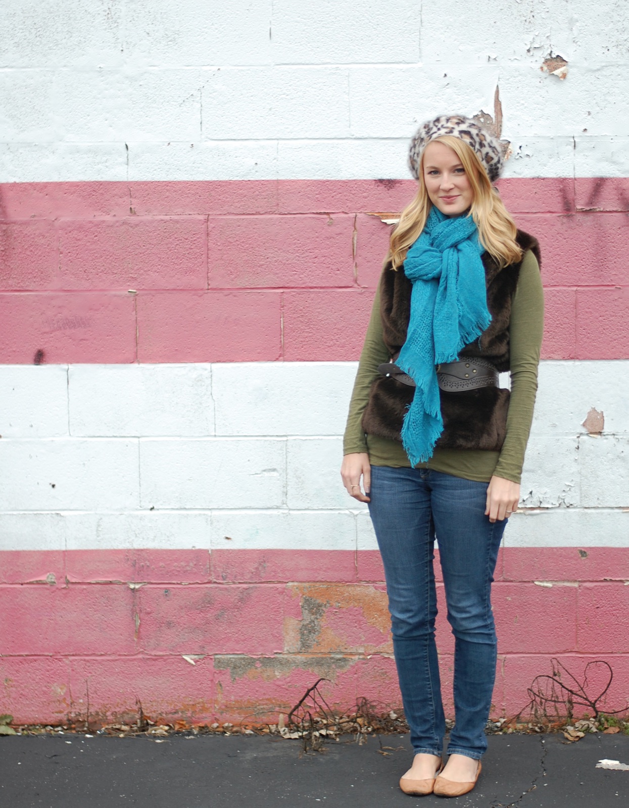 Young woman wearing a bright turquoise scarf with skinny jeans, ballet flats, a fur vest and a leopard beret in 2011