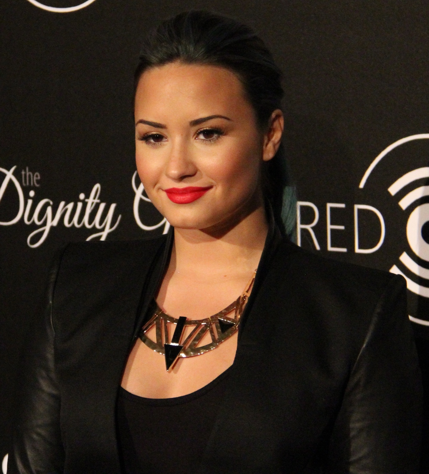 Demi Lovato wearing a large geometric metallic statement necklace with a black blazer in 2013