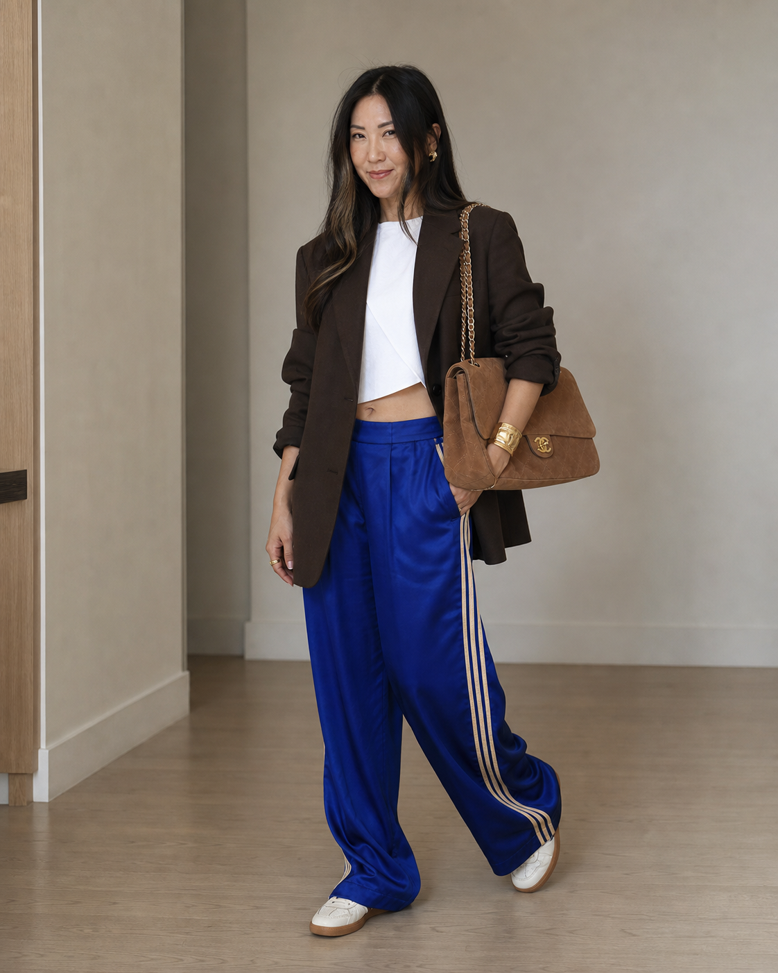 AI-generated image of Jenni wearing cobalt track pants, a chocolate blazer, and the Chanel camel suede Maxi Flap Bag.