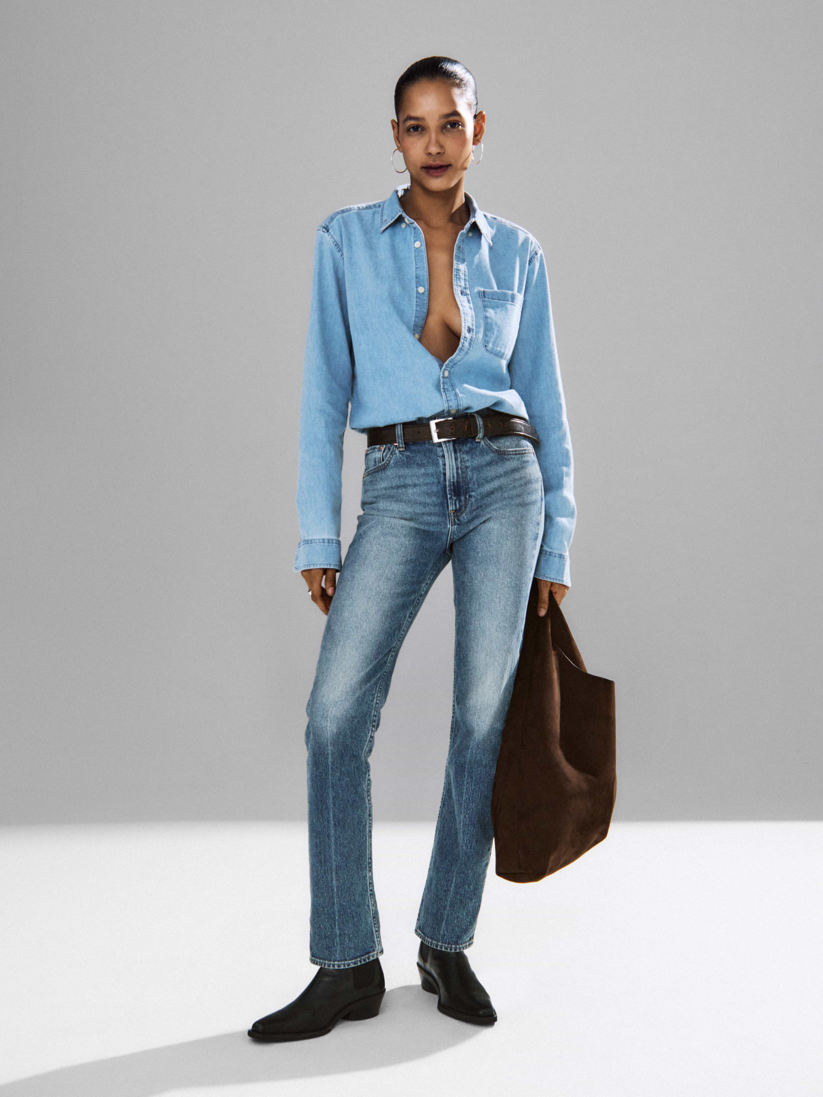 Model wearing denim and carrying Gap's Chocolate Cake Brown vegan-suede slouchy tote.