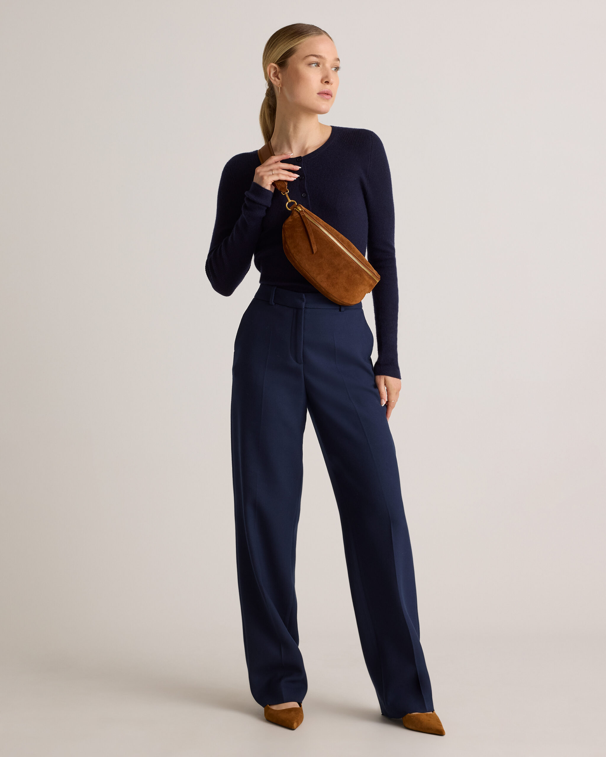Model in navy wearing the Quince Quinn Suede Sling Bag in Whiskey crossbody.