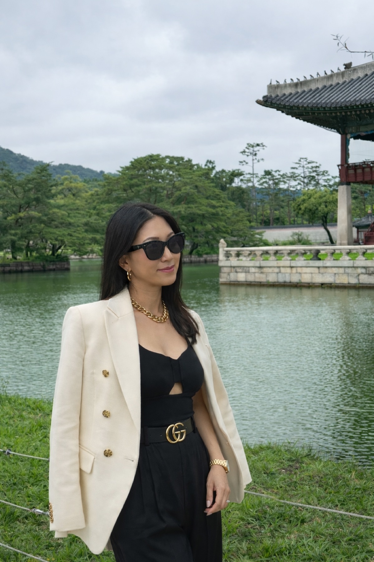 Jenni Kim wearing a cream gold-button military-style blazer over a black outfit in 2026